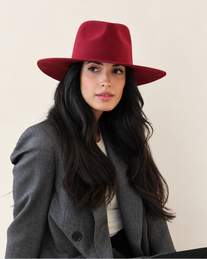 Seated model wearing Sable Wool Fedora Hat in Burgundy with gray outerwear