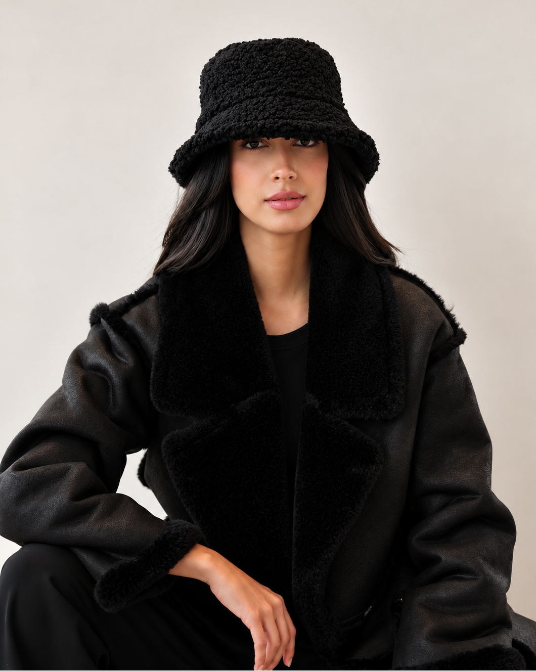 Front view of model wearing Shadow Nube teddy bucket hat with black coat