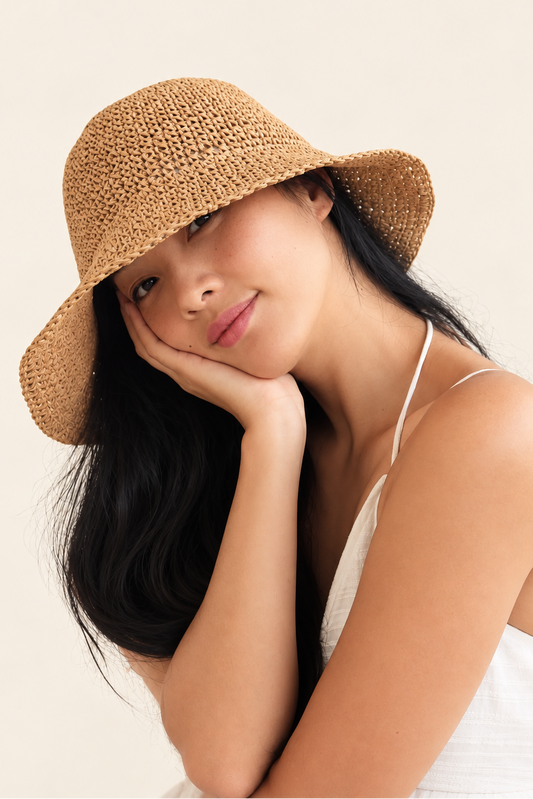 Model wearing Dune natural straw bucket hat with white summer dress, close-up lifestyle view