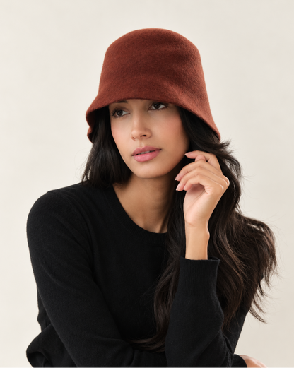Model posing in Terracotta wool bucket hat with black long sleeve top