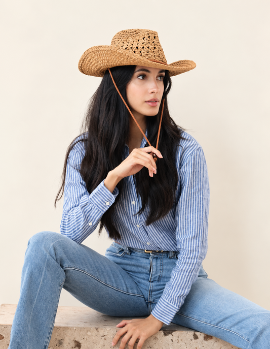 Model wearing Saddle Ridge Straw Cowboy Hat with blue denim outfit while seated
