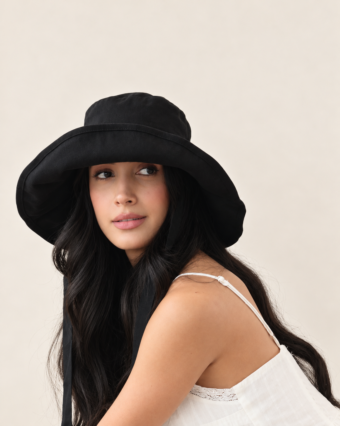 Model wearing Coast Midnight bucket hat with white outfit