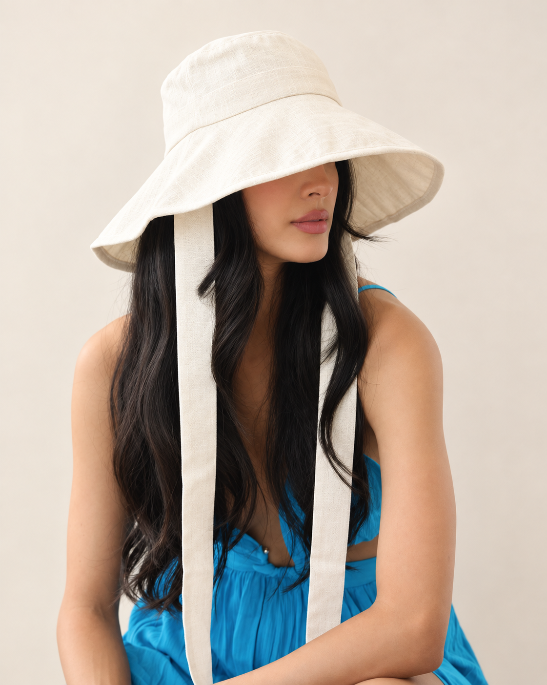 Model wearing Coast Cream cotton linen bucket hat with blue summer outfit