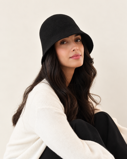 Side angle of model wearing Ember Wool Bucket Hat in Noir with white top