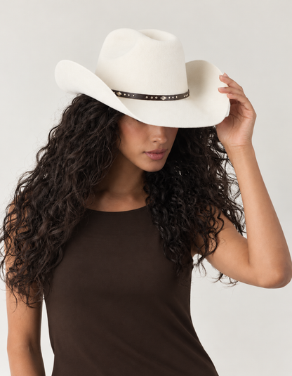 Model adjusting Cotton ivory Sedona Wool Cowboy Hat with curved western brim