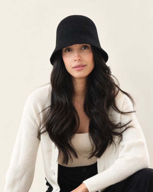 Model wearing Noir black Ember Wool Bucket Hat with white sweater