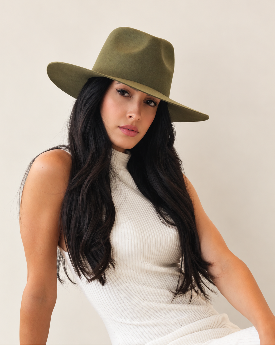 Angled view of Sable Wool Fedora Hat in Olive styled with white sleeveless top