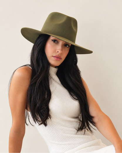 Angled view of Sable Wool Fedora Hat in Olive styled with white sleeveless top