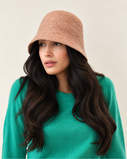 Close-up of model wearing Umber wool bucket hat with green sweater