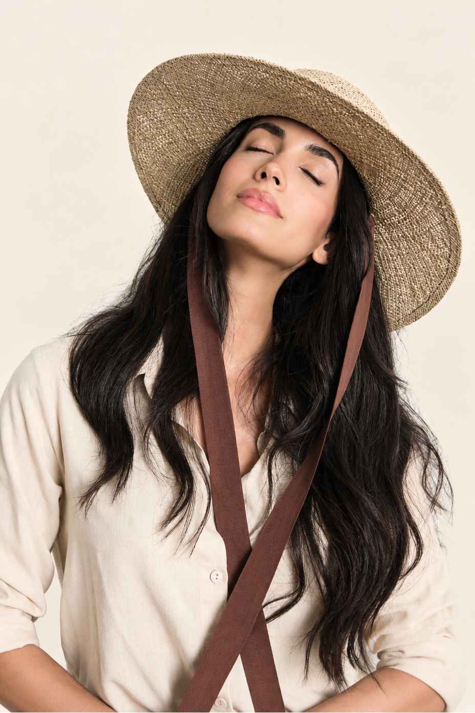 Model wearing Elise wide brim straw boater hat with brown ribbon, showing woven texture and brim