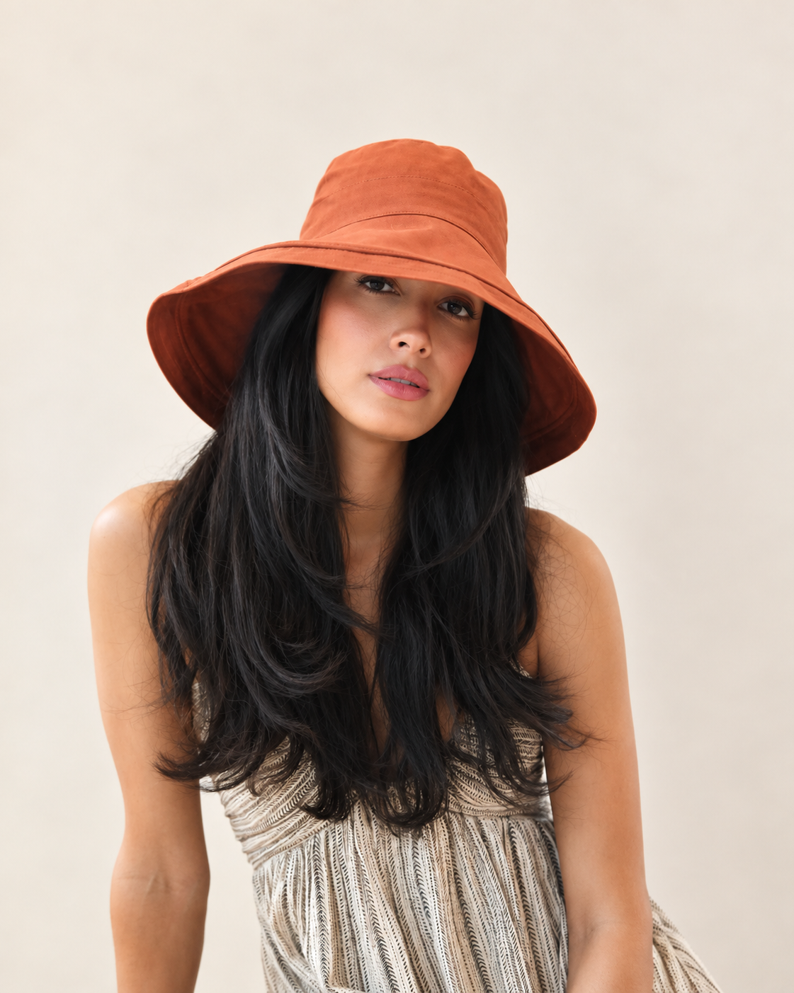 Model wearing cayenne Brisa canvas bucket hat with light summer outfit