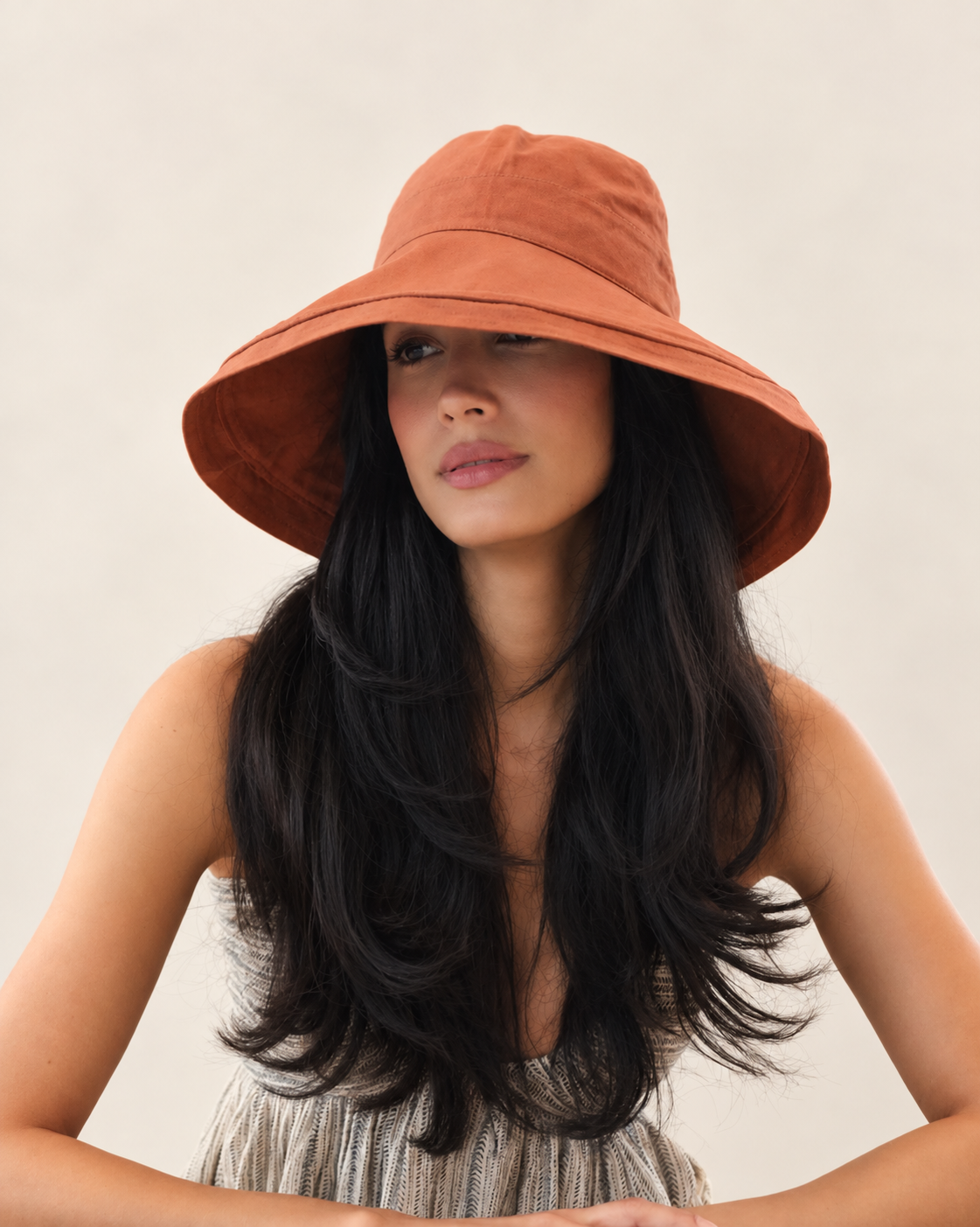 Model wearing cayenne Brisa canvas bucket hat with light summer outfit