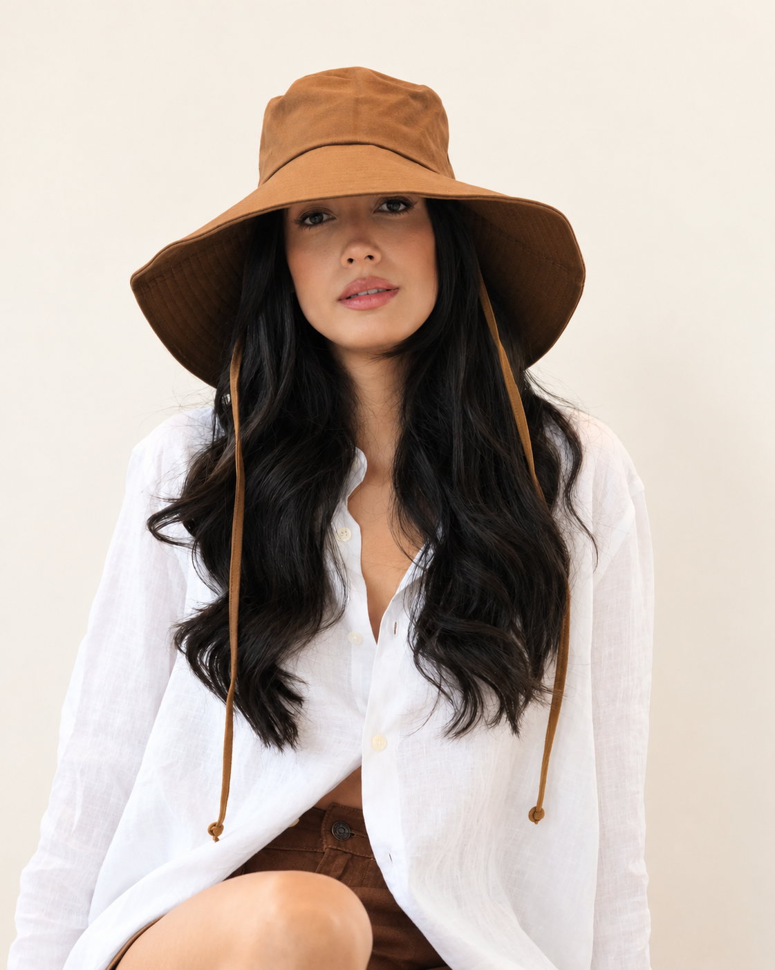 Front view of model wearing Chestnut brown canvas bucket hat with a white shirt