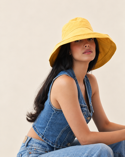 Model wearing Marigold Brisa canvas bucket hat with blue sleeveless outfit